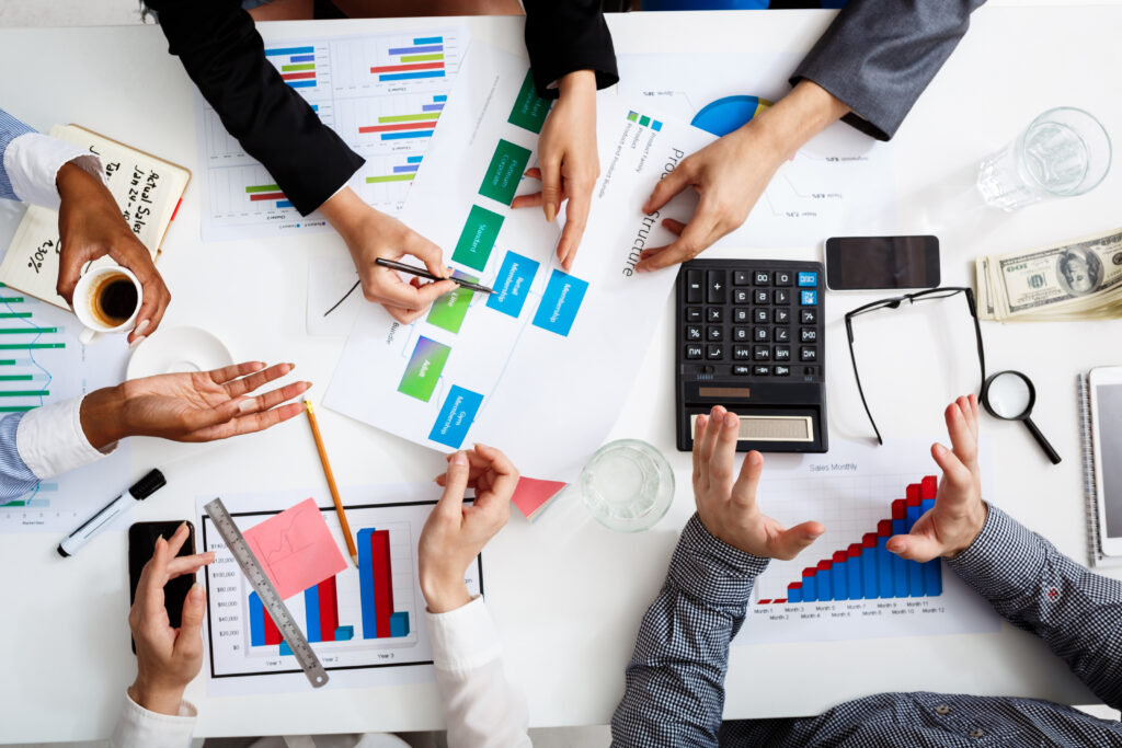 picture of businessmen's hands on white table with documents and drafts